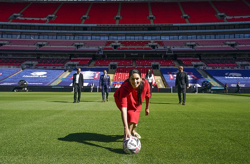 Aficionados mirando un partido en pantallas grandes de un bar deportivo