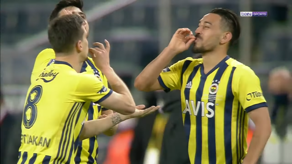 Vista aérea de un partido de fútbol con ambos equipos compactos